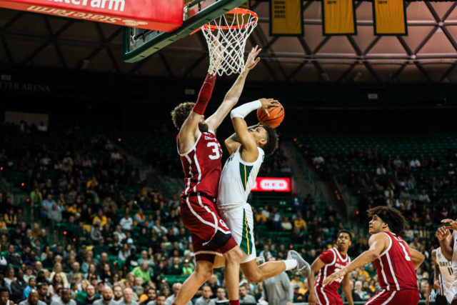 Freshman guard Keyonte George (1) tries to will the ball in the basket despite strong defense from a Sooner during a conference game against the University of Oklahoma, on Feb. 8, 2023, in the Ferrell Center. 
Kenneth Prabhakar | Photo Editor