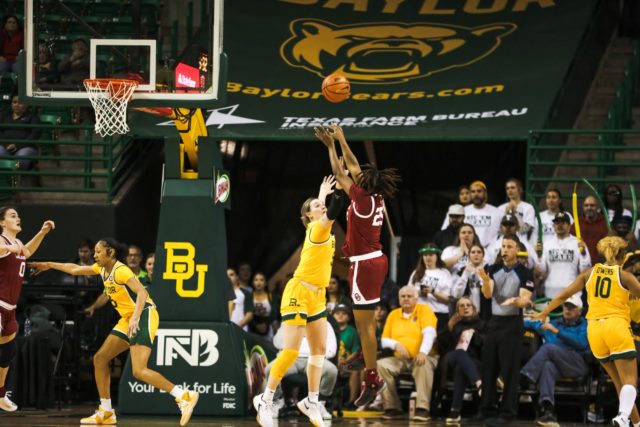 Caitlyn Bickle attempting to block a fade away jumper by an Oklahoma player. Assoah Ndomo | Photographer