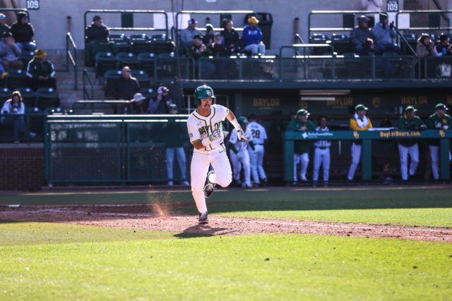 Freshman infielder Kolby Branch (13) runs down the base line after making contact with the pitch during the first game of a non-conference series against Central Michigan University, Friday, Feb. 17, 2023, at Baylor Ballpark. Assoah Ndomo | Photographer