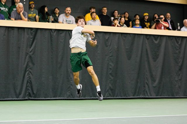 Junior Tadeas Paroulek with a hit to clinch him closer to winning the set during a non-conference match against No. 4 University of Michigan, Friday, Feb. 3, 2023, in the Hawkins Indoor Tennis Center. Assoah Ndomo | Photographer