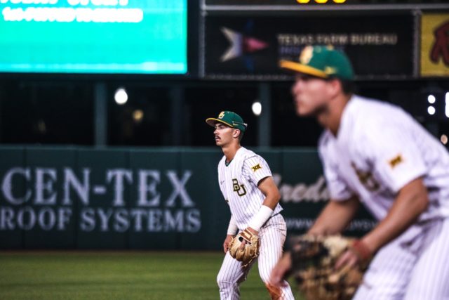 Freshman infielder Kolby Branch, left, and sophomore first baseman John Ceccoli, right, get in their defensive stance ahead of the pitch during a non-conference midweek game against Houston Christian University, Tuesday, Feb. 21, 2023, at Baylor Ballpark.
Assoah Ndomo | Photographer