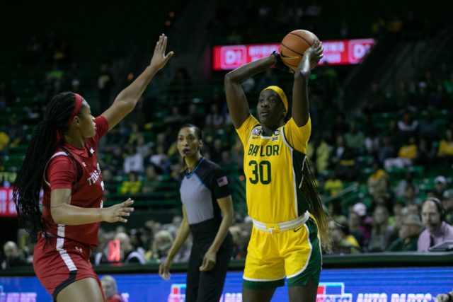 Junior guard Catarina Ferreira (30) looks to pass the ball with the basketball above her head during a conference game against Texas Tech University, Feb. 25, 2023, in the Ferrell Center.
Katy Mae Turner | Photographer