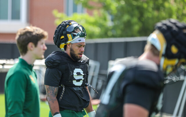 Fifth-year senior defensive lineman TJ Franklin (9) lifts his helmet up and walks toward the sideline during Baylor football's third day of spring camp, on Tuesday, at the team's outdoor practice field.
Kenneth Prabhakar | Photo Editor