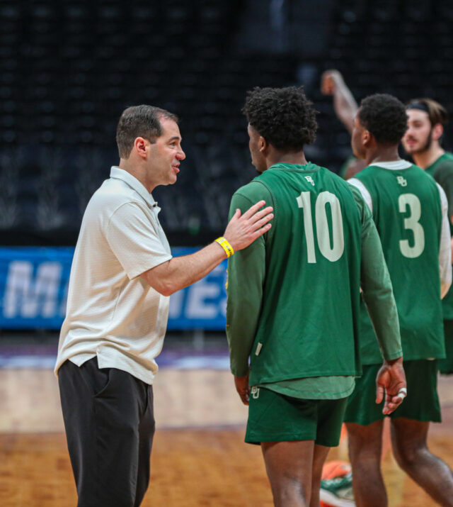 Head coach Scott Drew, left, pats redshirt senior guard Adam Flagler, 10, right, on the shoulder and talks to him during No. 3 seed Baylor men's basketball's team practice ahead of its round of 64 contest against the University of California, Santa Barbara, on Thursday, in the Ball Arena, in Denver. 
Kenneth Prabhakar | Photo Editor