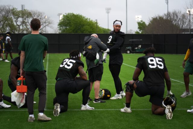 Fifth-year senior defensive lineman TJ Franklin (9) gets his hand wrapped by a team member during Baylor football's first practice of the spring, on Tuesday, at the team's outdoor practice field.
Olivia Havre | Photographer
