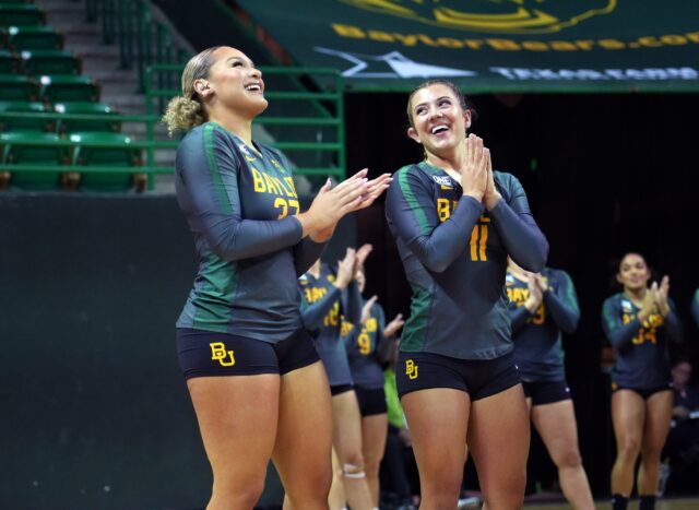 Junior base Riley Chimwala, left, 37, and junior top and tumbler Brennah Cotner, right, 11, smile in reaction to the team's points during No. 1 Baylor acrobatics & tumbling's meet against No. 12 Frostburg State University, on Wednesday, in the Ferrell Center.
Olivia Havre | Photographer