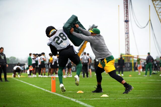Redshirt senior running back Qualan Jones (left, 28) gets bumped off his path by assistant head coach and running backs coach AJ Steward (right), during Baylor football's fourth day of spring practice, on March 30, at the team's outdoor practice field.
Olivia Havre | Photographer