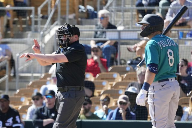 Home plate umpire Paul Clemons, left, calls a pitching clock violation against Chicago White Sox relief pitcher Reynaldo Lopez as Seattle Mariners' AJ Pollock (8) looks on during the third inning of a spring training baseball game on Monday in Phoenix. (AP Photo/Ross D. Franklin)
