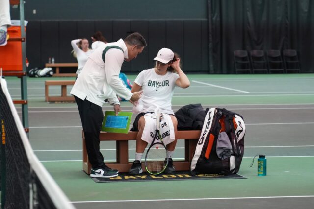 Head coach Joey Scrivano, left, talks with senior Isabella Harvison, right, during Baylor women's tennis' non-conference match against No. 41 University of Denver Tuesday in the Hawkins Indoor Tennis Center. Olivia Havre | Photographer