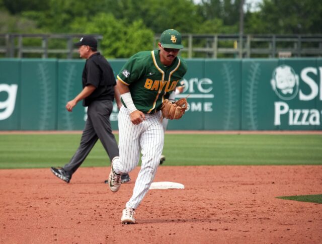 Freshman infielder Kolby Branch (13) runs back toward the dugout after the Bears got the final out of the inning during Baylor baseball's midweek contest against Tarleton State University Tuesday afternoon at Baylor Ballpark. Olivia Havre | Photographer