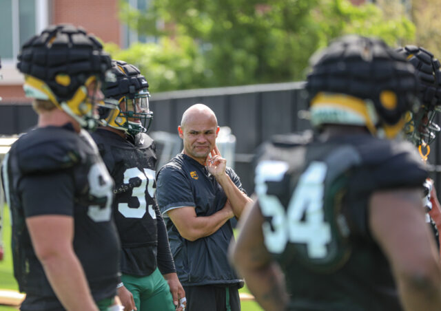 Head coach Dave Aranda stands near some of his players during Baylor football's third day of spring camp, on March 28, at the team's outdoor practice field. Kenneth Prabhakar | Photo Editor