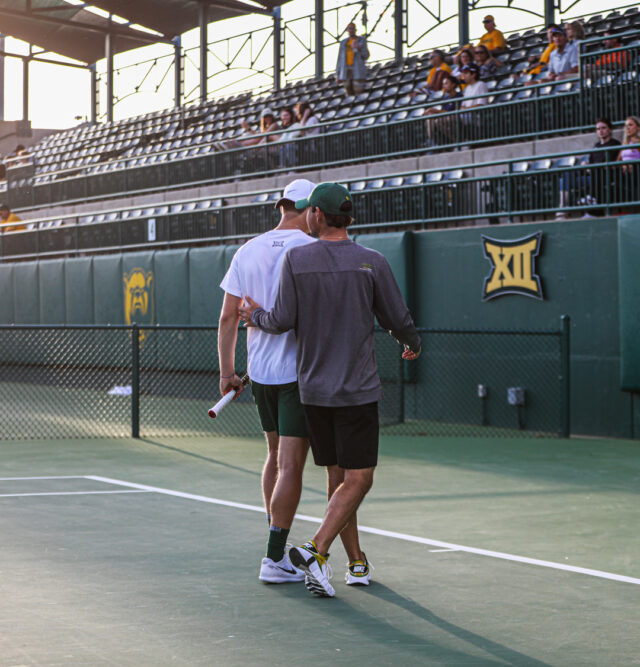 Head coach Michael Woodson (right) consoles one of his athletes during Baylor men's tennis' Saturday doubleheader against the University of Texas Rio Grande Valley and Texas Tech University, on April 1, at the Hurd Tennis Center. Kenneth Prabhakar | Photo Editor