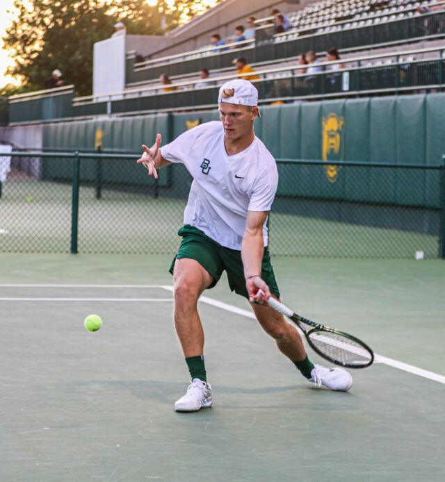 Freshman Zsomber Velcz keys in on the ball and returns it during Baylor men's tennis' Saturday doubleheader against the University of Texas Rio Grande Valley and Texas Tech University, on April 1, at the Hurd Tennis Center. Kenneth Prabhakar | Photo Editor