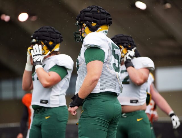 Fifth-year senior offensive lineman Clark Barrington (56, middle) stands with some teammates while rain comes down during Baylor football's seventh practice of the spring on Thursday at the team's outdoor practice field.
Olivia Havre | Photographer