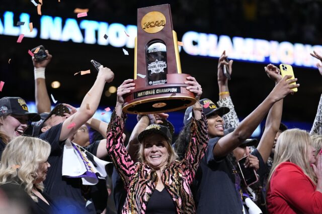 LSU head coach Kim Mulkey holds the winning trophy after the NCAA Women's Final Four championship basketball game against Iowa Sunday in Dallas. LSU won 102-85 to win the championship. (AP Photo/Tony Gutierrez)