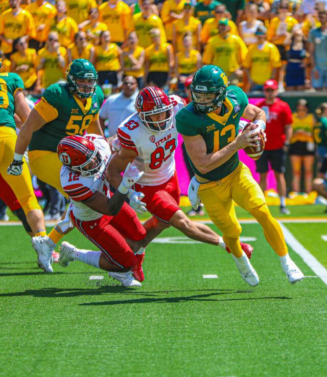 Redshirt sophomore quarterback Sawyer Robertson (13) evades two Utes defenders during Baylor football's non-conference contest against No. 12 Utah on Saturday at McLane Stadium. Kenneth Prabhakar | Photo Editor