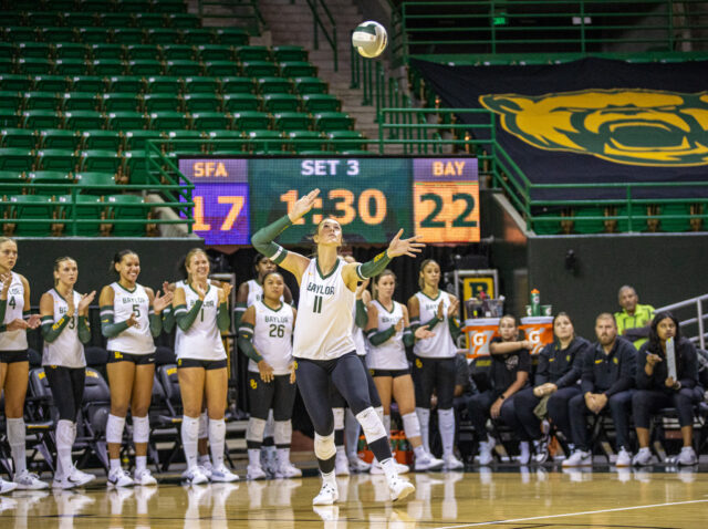 Freshman outside hitter Kendal Murphy (11) lobs the ball ahead of a service during No. 18 Baylor volleyball’s nonconference match against Stephen F. Austin Tuesday night in the Ferrell Center. Lilly Yablon | Photgrapher