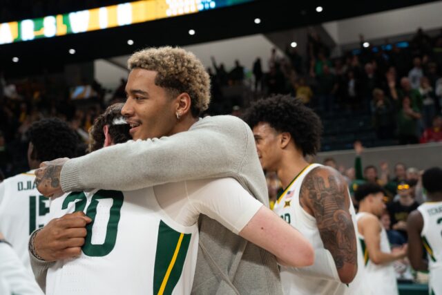 Former Baylor forward Jeremy Sochan (right) hugs his former teammates after sitting courtside for Tuesday's game. Sochan, a one-and-done player from the 2021-22 season, is in his second year with the San Antonio Spurs. Camie Jobe | Photographer