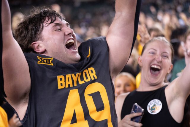 Trey Laurence, Redshirt Freshman LineBacker, celebrates with fans after the student section storms the field after Baylor Football's 37-34 win over TCU on saturday night at Mclane Stadium. Mesha Mittanasala | Photographer