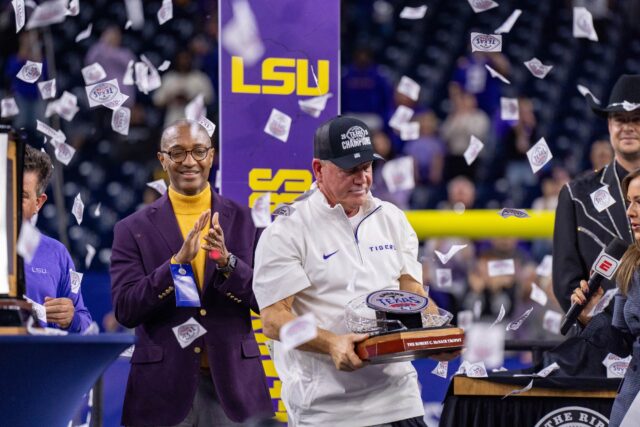 LSU head coach Brian Kelly receives the Kinder Texas Bowl trophy during LSU's win against Baylor Tuesday night at NRG stadium in Houston. Mesha Mittanasala | Photographer