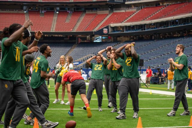 Baylor football offensive linemen practice passes with children from DePelchin Children's Center during the Kinder's Texas Bowl DePechlin Field Day on Monday at NRG Stadium in Houston. Mary Thurmond | Photo Editor