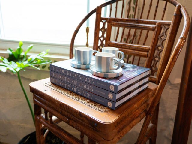 A stack of books and coffee mugs in a tidy corner of the Carpenter's Daughter. Brady Harris | Photographer