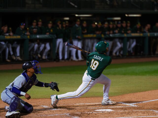 Senior catcher Cortlan Castle drives one out to left field in the