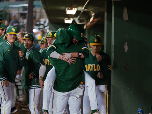 Freshman second basemen Pearson Riebock jumps and hugs his teammate in the Bears' 7-2 win against Tarleton tuesday night at Baylor Ballpark