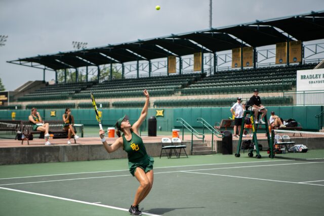 Senior Cristina Tiglea serves in her doubles match against Oklahoma State University at the Hurd Tennis Center on March 30th. Camie Jobe | Photographer