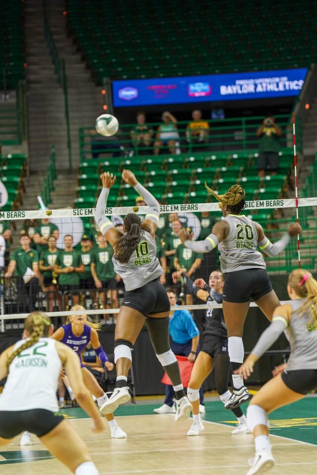Graduate Student Middle Blocker Gabrielle Essix jumps to block a serve during the Baylor vs Northwestern University volleyball game at the Ferrell Center. Caleb Garcia | Photographer