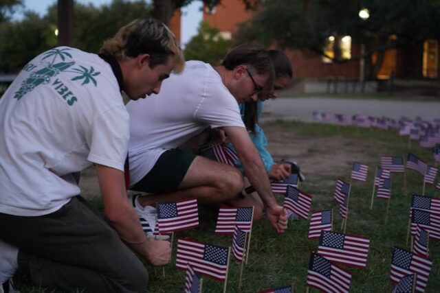 Volunteers place American flags on Rosenbaum Fountain for the Charlie Kirk Prayer Gathering on Wednesday night. Caleb Garcia | Photographer