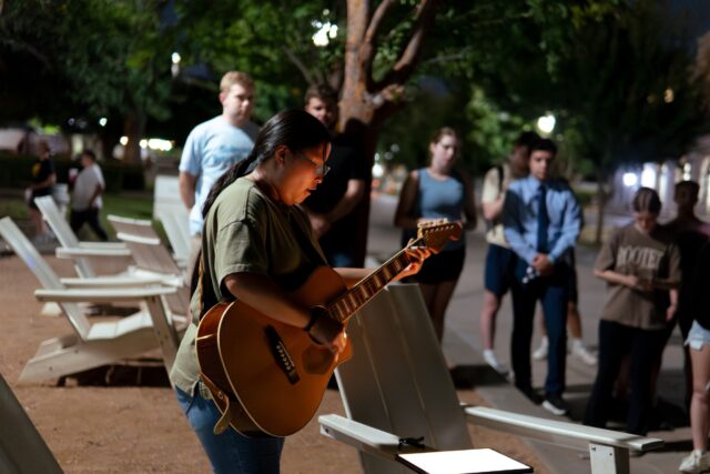 A student musician passionately sings during the prayer gathering for Charlie Kirk Wednesday night at Fountain Mall. Brady Harris | Photographer