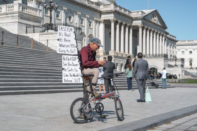 Outside the Capitol building a protestor rides his bike carrying messages calling its readers to action Thursday morning in Washington, D.C. Jake Schroeder | Photographer