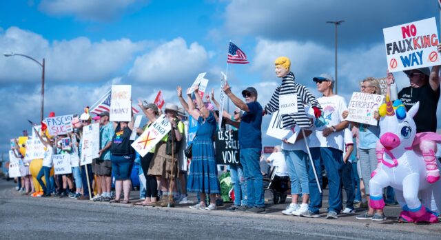 Hundreds of Waco citizens lined the parking lot of the Westview Village shopping mall with signs, flags, and inflatable suits. Mary Thurmond | Photo Editor