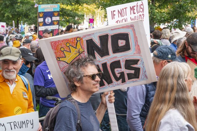 With crowds packed close together, protestors brandished their signs as they waited for the first speakers of the event to enter onto the stage. Jake Schroeder | Photographer