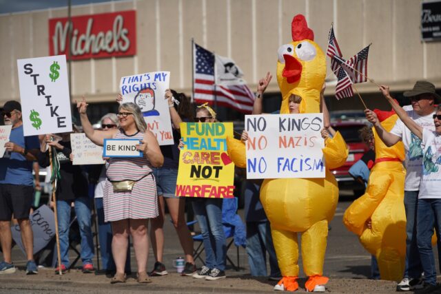 Protesters bear signs, chant slogans and wave American flags at the No Kings Protest on Saturday morning on the corner of Valley Mills Drive in Waco. Caleb Garcia | Photographer