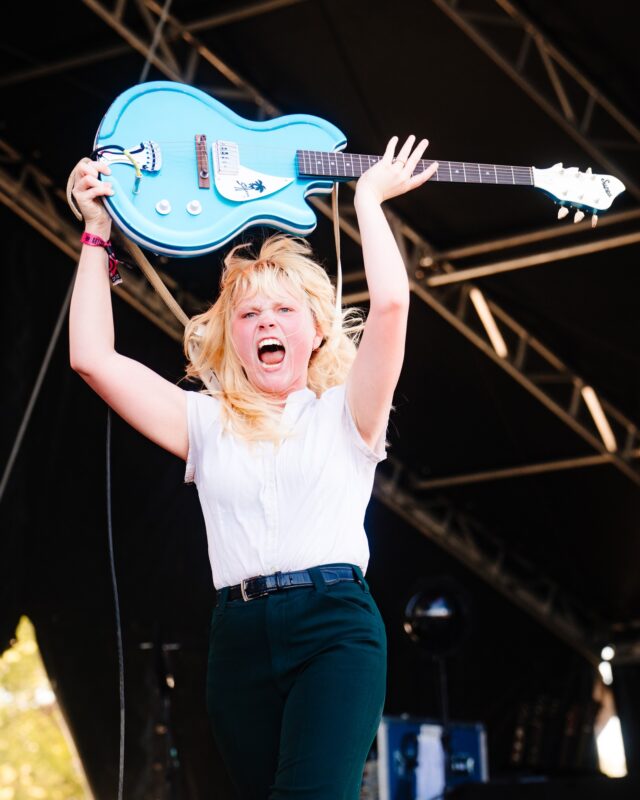 Kenzie Crowe, vocalist and guitarist of Girl Tones, thrusts her light blue electric guitar above her head during the band's set Friday. Photo courtesy of Roger Ho