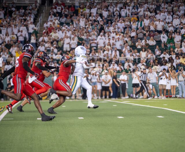 Redshirt sophomore running back Bryson Washington is swarmed by the opposing defense at the Baylor vs Utah Football game on Saturday night at McLane Stadium. Caleb Garcia Photographer