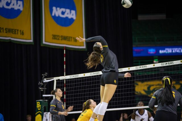 Sophomore outside hitter MJ McCurdy hits the ball over the net during the Bears’ 3-0 victory over West Virginia at the Ferrell Center Friday. Sam Gassaway | Photographer