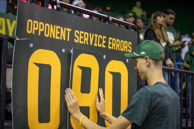 Senior Tryston McGuyre updates the "opponent service errors" board, now totaling over 90 service errors this season. Sam Gassaway | Photographer