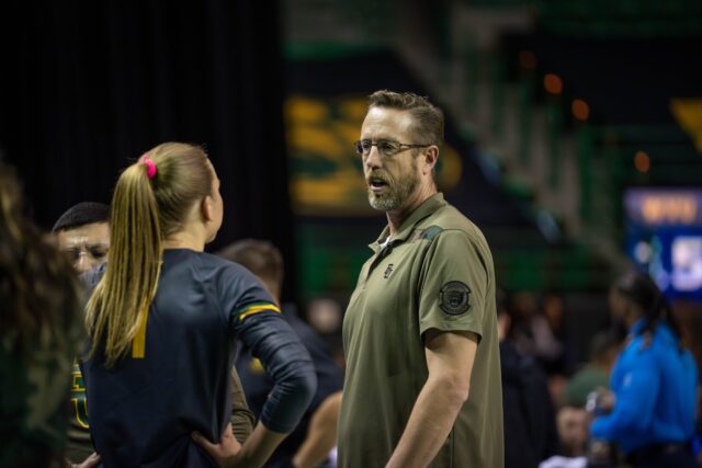 Head coach Ryan McGuyre debriefs redshirt sophomore setter Harley Kreck in a timeout during the Bears victory over West Virginia Friday. Sam Gassaway | Photographer