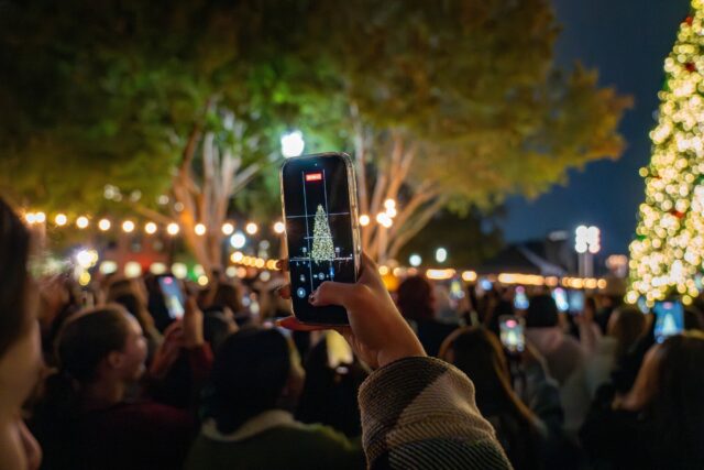 Baylor students were eager to get a perfect shot of the Christmas tree lighting on fountain mall on Thursday. Sam Gassaway | Photographer