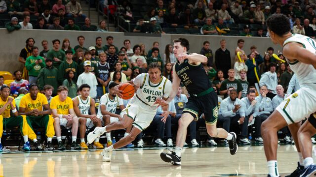 Redshirt sophomore guard Cameron Carr drives powerfully towards the basket through a defender. Brady Harris | Photographer