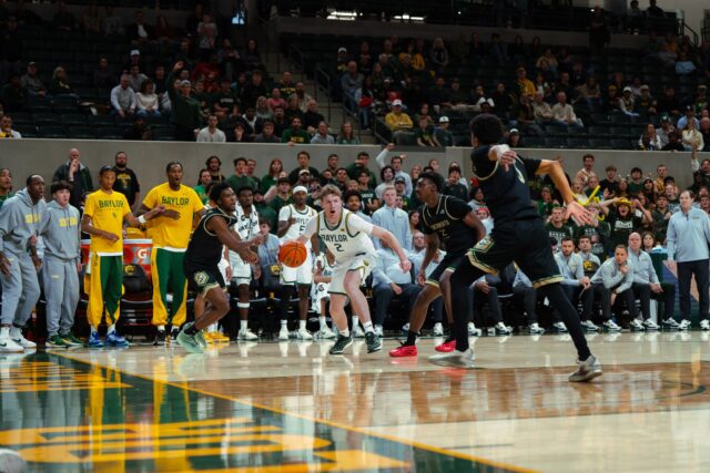 Redshirt sophomore guard Will Kuykendall slides past two defenders to drive towards the basket. Brady Harris | Photographer