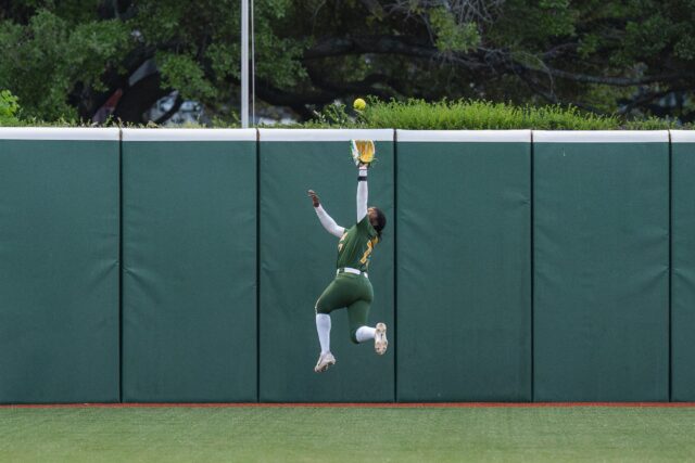 Sophomore right fielder Sa’Mya Jones makes a leaping grab of the ball at the wall to record the out. Jake Schroeder | Photographer