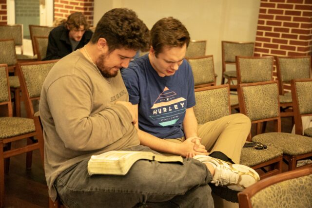 Cypress senior Peter Stewart prays with his friend, Isaiah, during "Awake." Hannah Webb | Opinion Editor