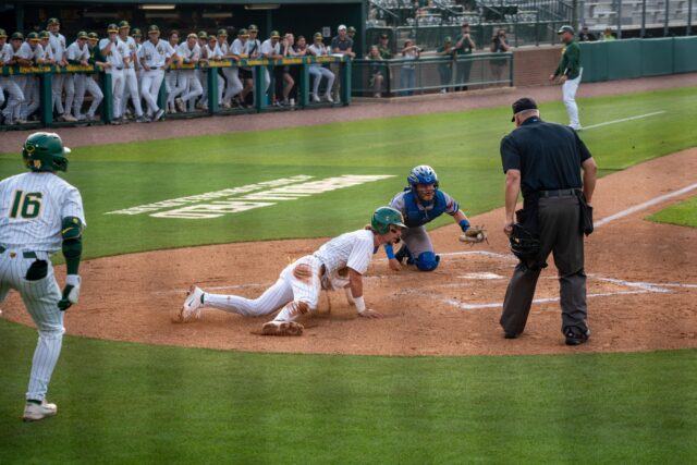Redshirt junior infielder Travis Sanders slides across home plate, scoring a point for the Bears during their 6-2 victory over UTA on Tuesday. Sam Gassaway | Photo Editor
