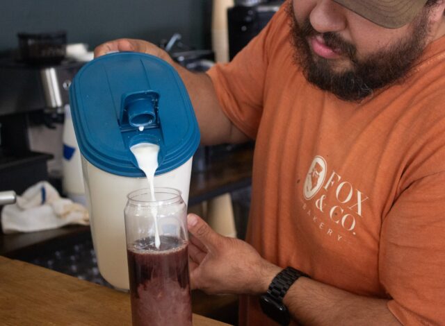 Owner Victor Hernandez pours cream over espresso as he creates a can sealed coffee. Alexandra Brewer | Arts & Life Writer