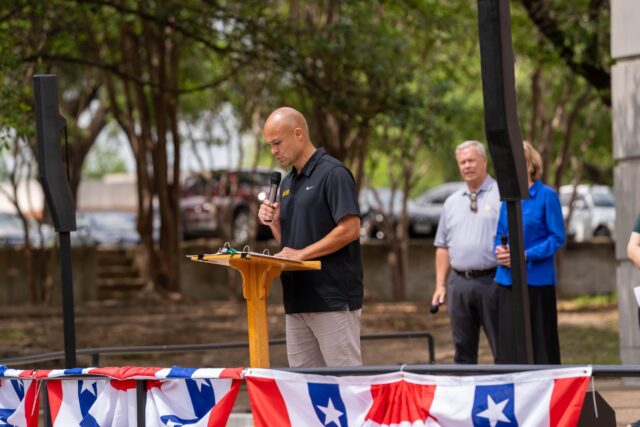 Head Football Coach reads a section of the Declaration of Independence at the SUB Bowl on Friday afternoon. Caleb Garcia | Photographer
