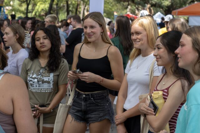 Students crowd around a table, attentively listening to the volunteer during the Church Fair at Fountain Mall on Friday at 10:00 AM. Vanessa Adams | Photographer